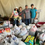 people behind bags and boxes of food drive items