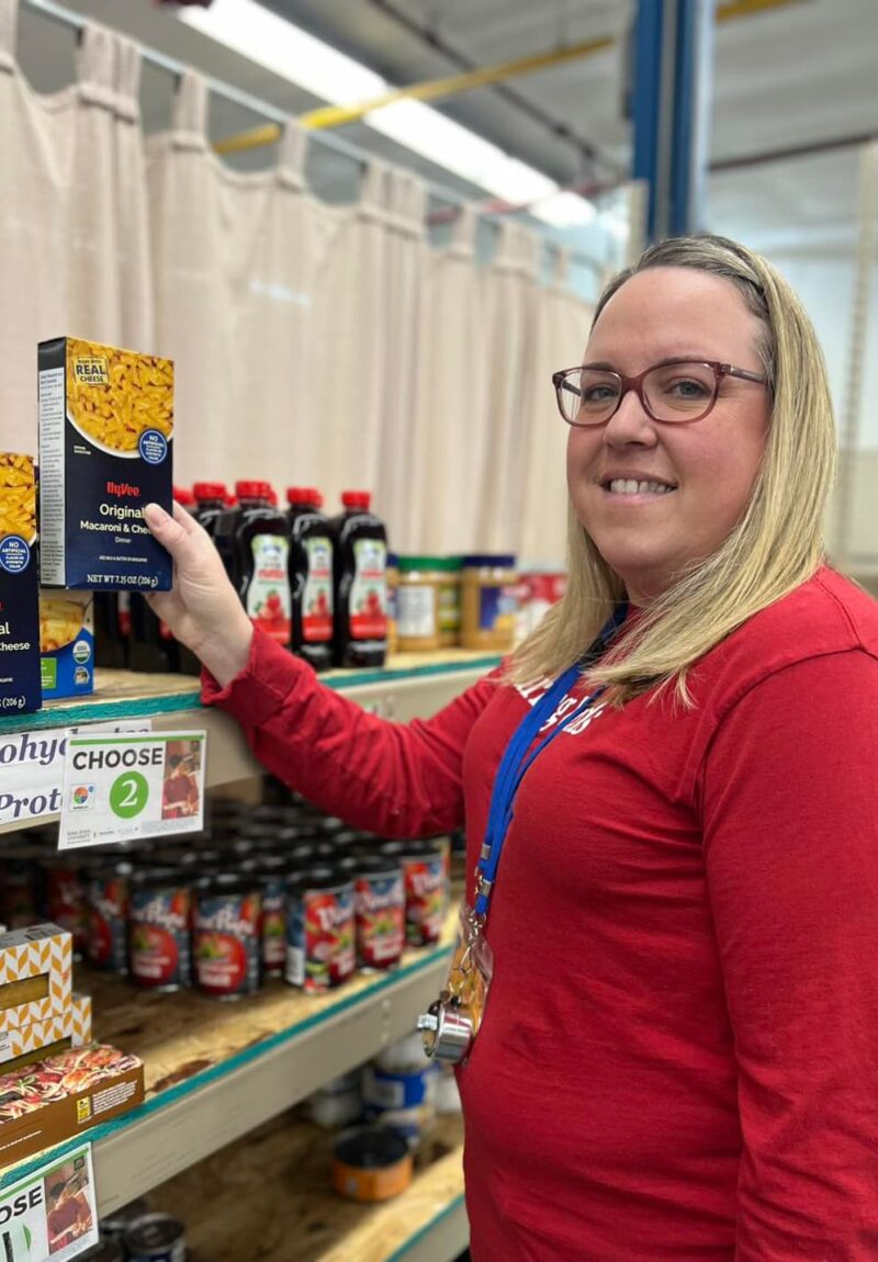 480268828_1063874632451729_4874388613044719563_n-min person stocking food pantry shelves with macaroni