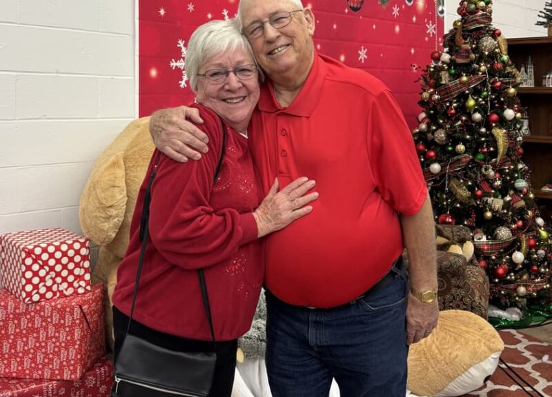 ae3c99_a88b78596e6b42b7a817d56d4dadc075~mv2-min two people hugging with christmas decoration