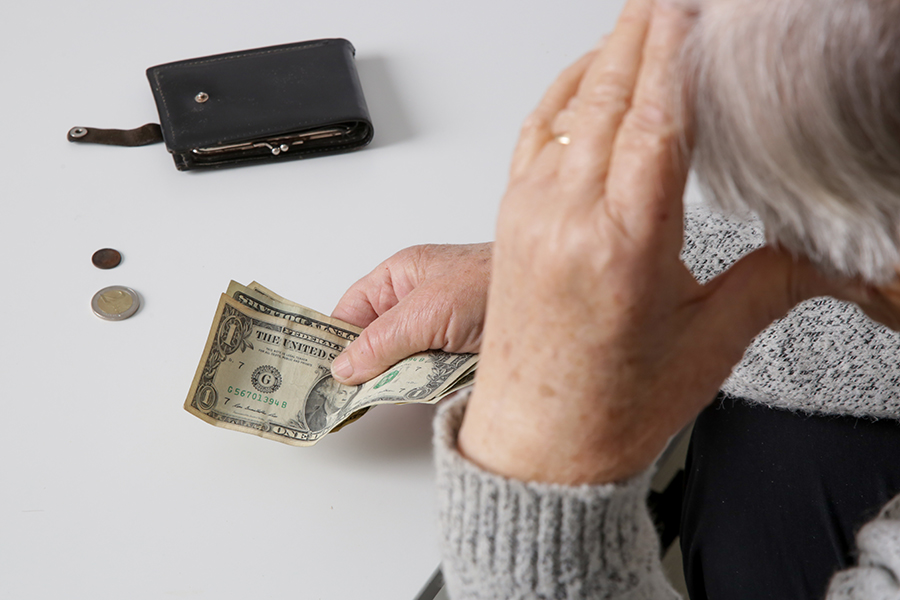 person holding money with hand on head