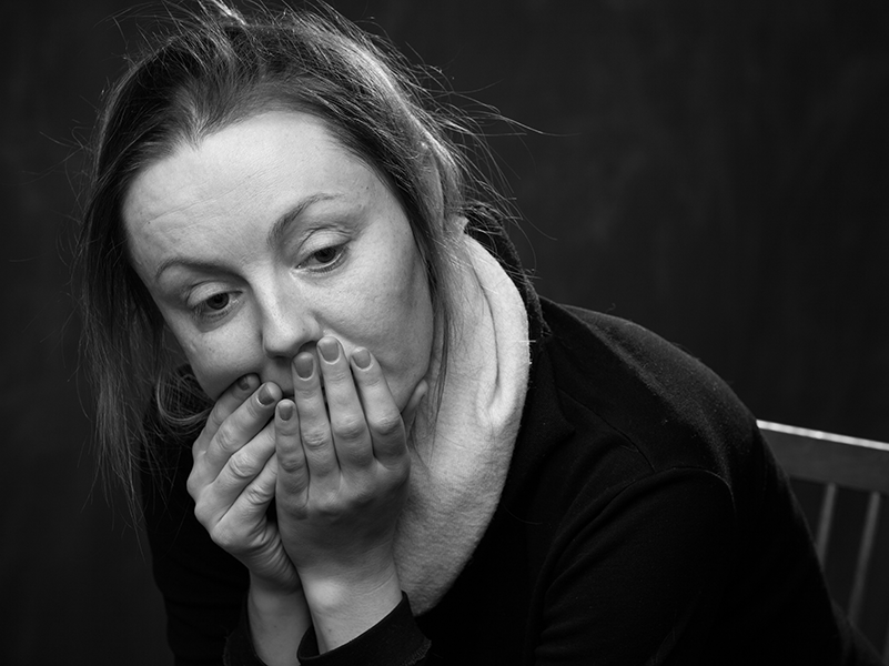 Person looking worried with hands over mouth