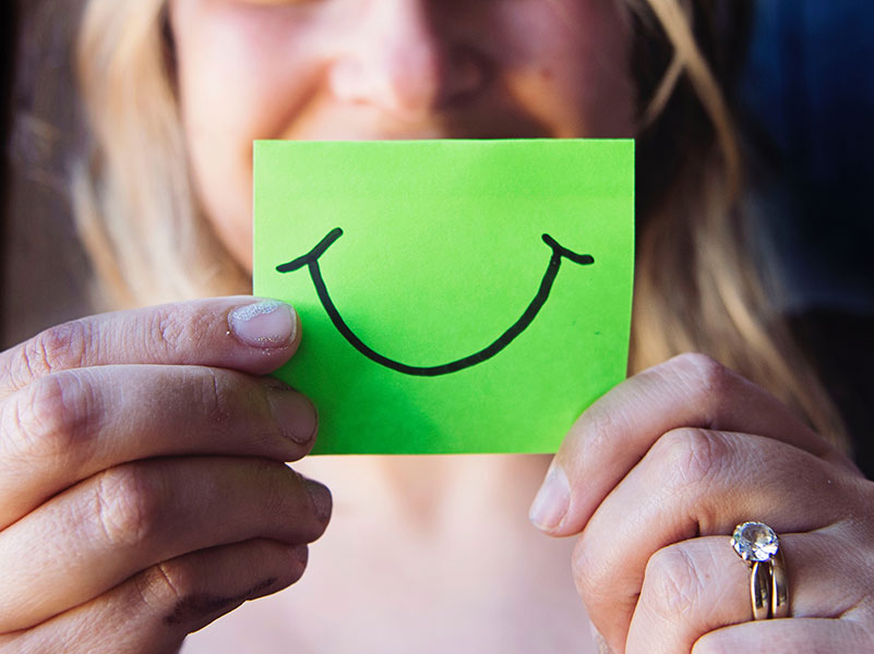 Person holding smile on post-it