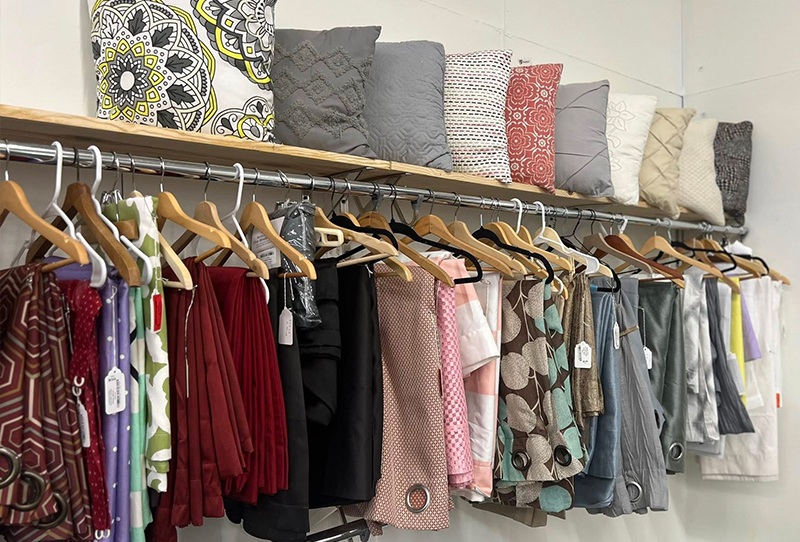 home-goods-new shelf of throw pillows and curtains hanging for resale